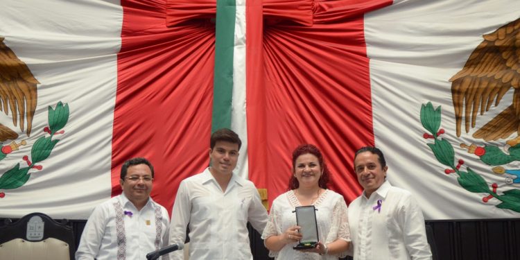 Galardonan a mujer con medalla al mérito, por investigación neurosensorial oncológica